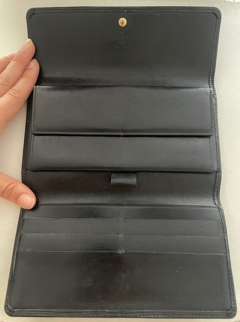 LOUIS VUITTON ANNÉE 1993 - Portefeuille en cuir épi noir, compartiments cartes,…