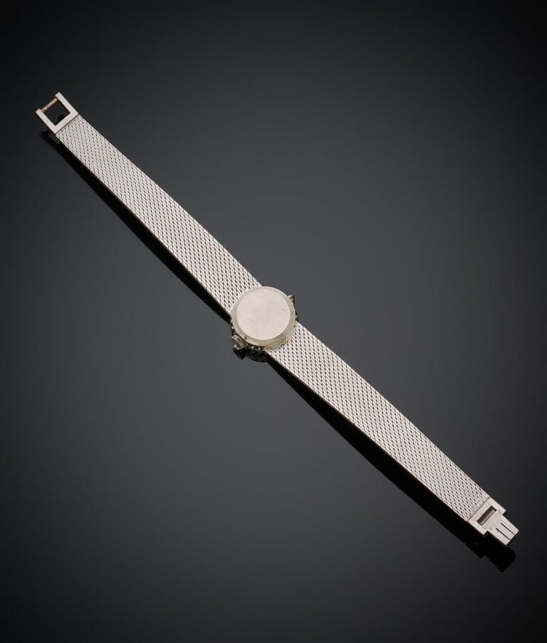 OMEGA - BRACELET MONTRE ronde de dame en or gris (750‰). Lunette sertie d'émera…