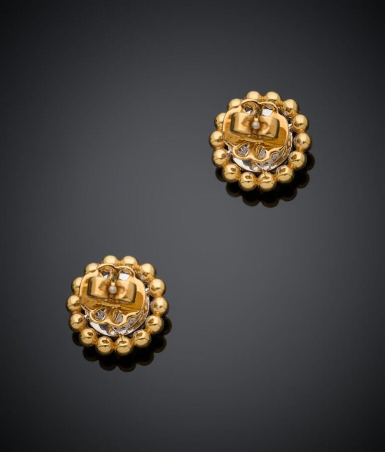 Paire de CLOUS d'OREILLES "fleur" en or jaune et or gris (750‰) serti de diaman…