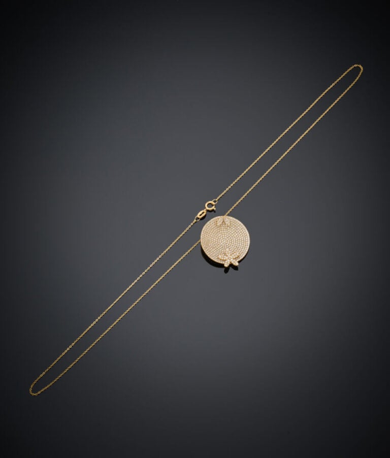 PENDENTIF circulaire et sa chaînette en or jaune (750‰) pavé de diamants taille…