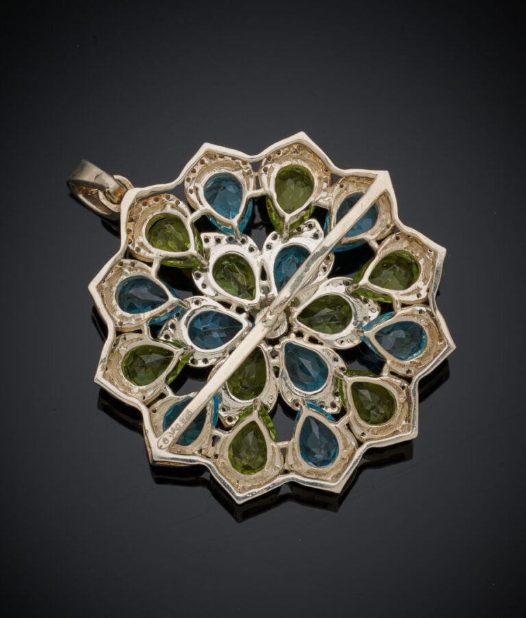 PENDENTIF "fleur" et sa chaîne en argent (925‰) ajouré, serti de topazes bleues…