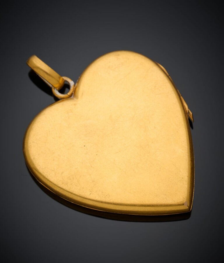 PENDENTIF PORTE-SOUVENIR "cœur" en or jaune (750‰) ciselé, orné de pierres roug…