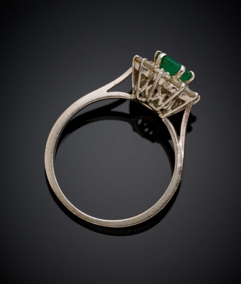 Petite BAGUE "marguerite" en or gris (750‰) serti d'une émeraude ovale entourée…