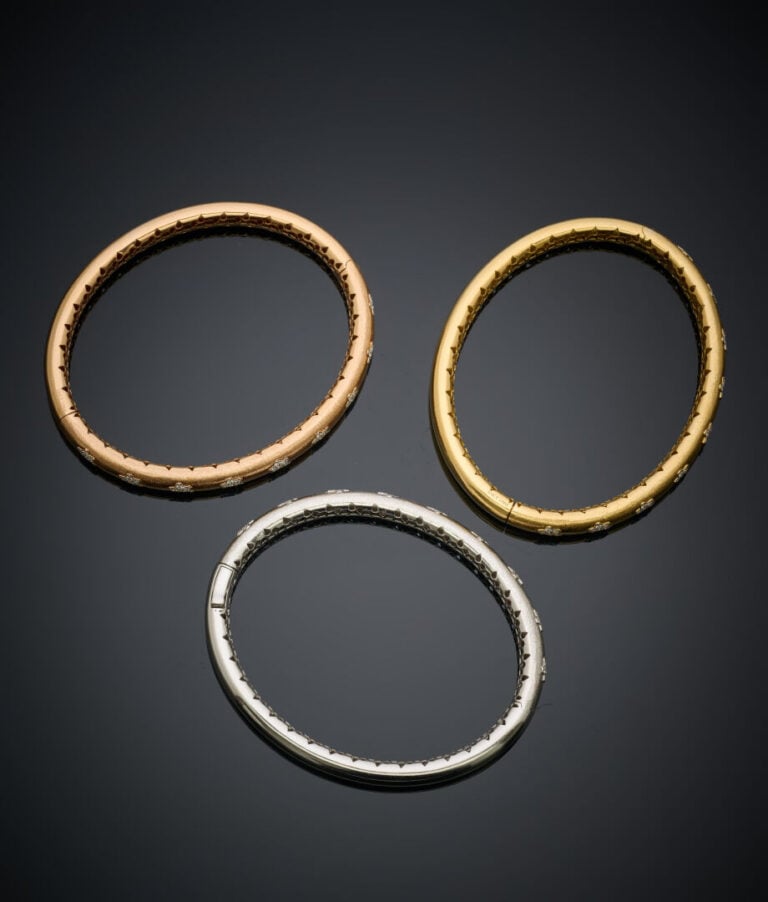 Trois BRACELETS joncs ouvrants en or jaune, gris et rose (750‰) amati, orné de…